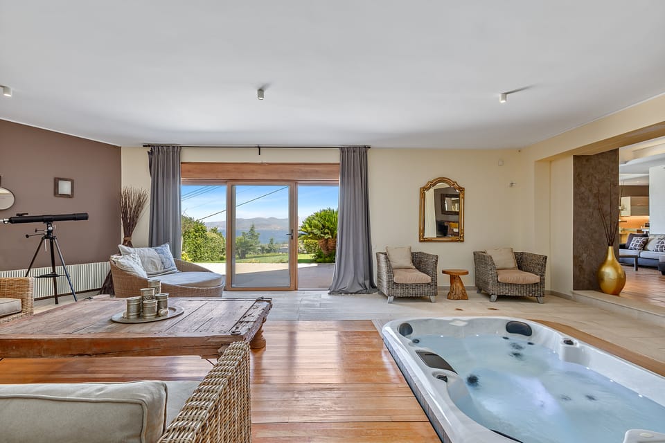 The Charis jacuzzi lounge with rattan chairs opening onto the sea-view terrace