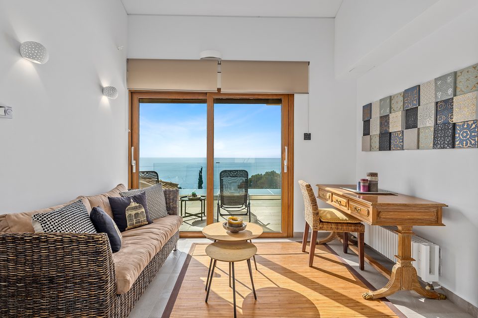 A top-floor View House sitting room with a writing desk and terrace doors opening over the gulf